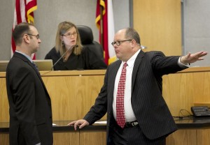Former prosecutor Steve Brand, left, and defense lawyer Jon Evans, right, confer at the bench with Judge Julie Kocurek in the capital murder trial of Darius Lovings.